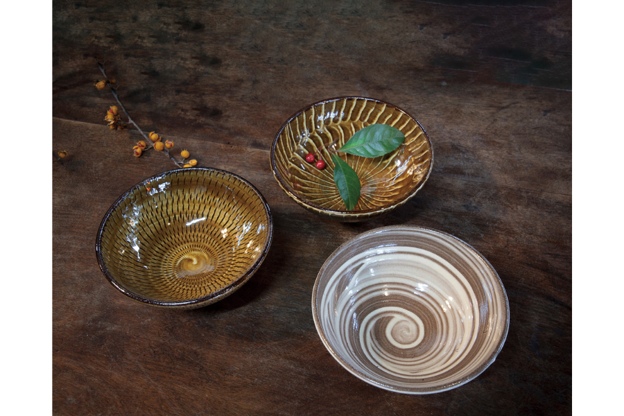 小石原焼の伝統的技法「飛び鉋（左）」、 「刷毛目（右上）」、「藁刷毛（右下）」で模様 を描いた茶碗1個1,000円（やままる窯）